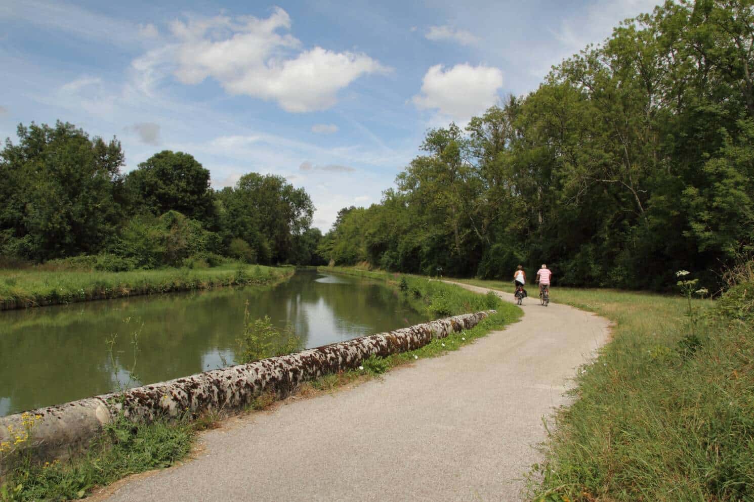 2 cyclistes se baladent sur le chemin de halage le long du canal du Nivernais