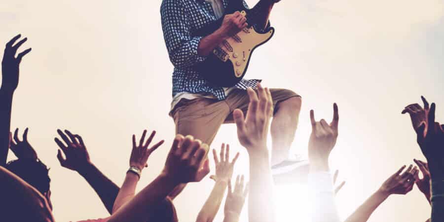 Closeup of diverse arms raised in live music concert fetedelamusique2