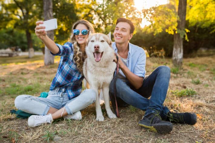 cool jeune couple elegant jouant avec un chien dans le parc