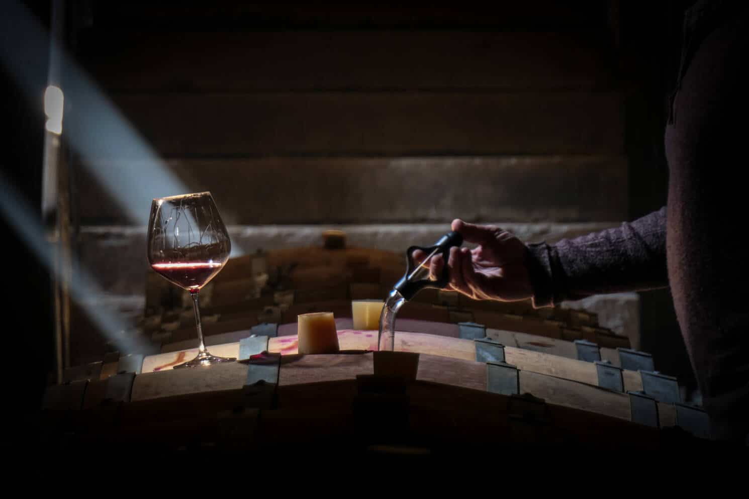 Un verre de vin sur un tonneau en bois pour l'élevage du vin